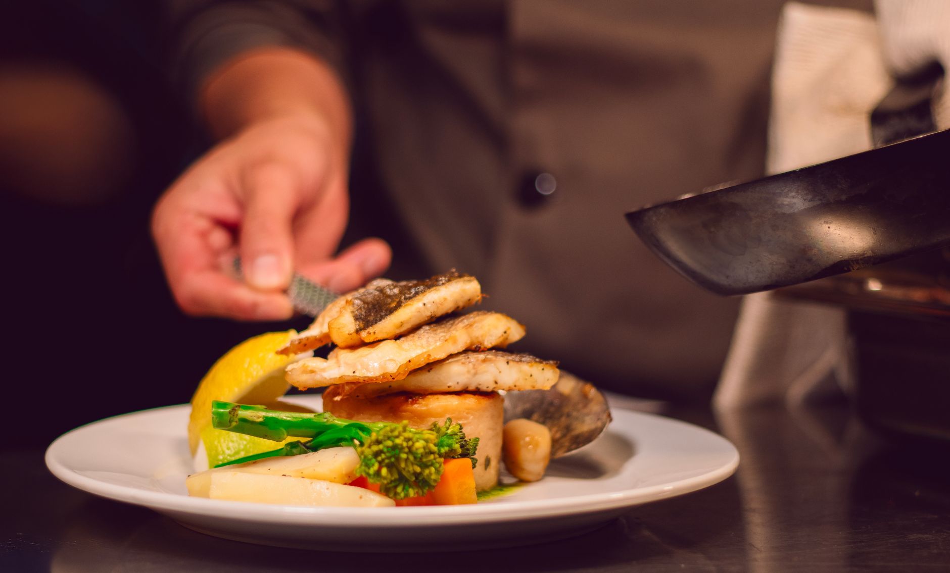 Chef plating a fish dish