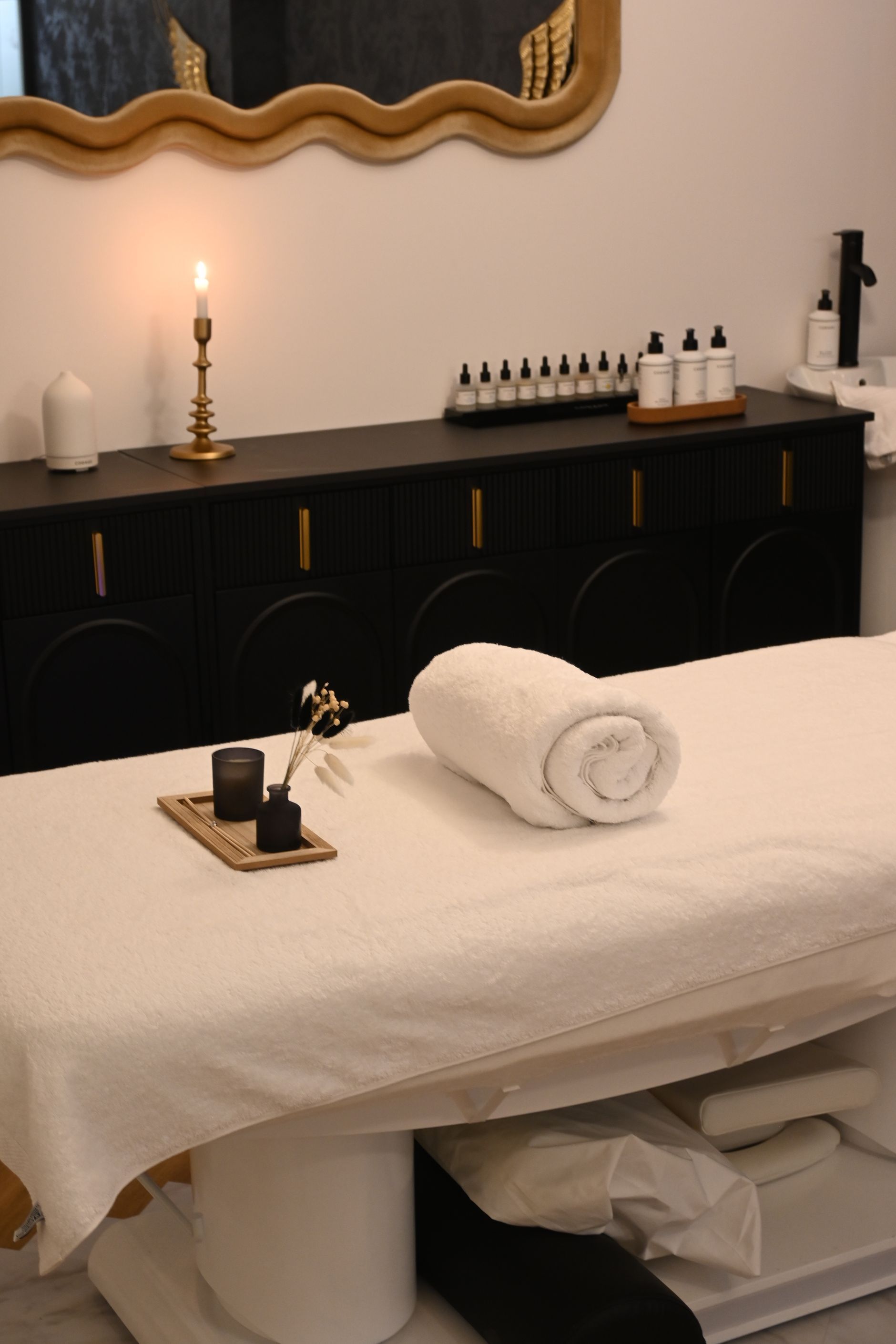 Spa room with a rolled towel and candles