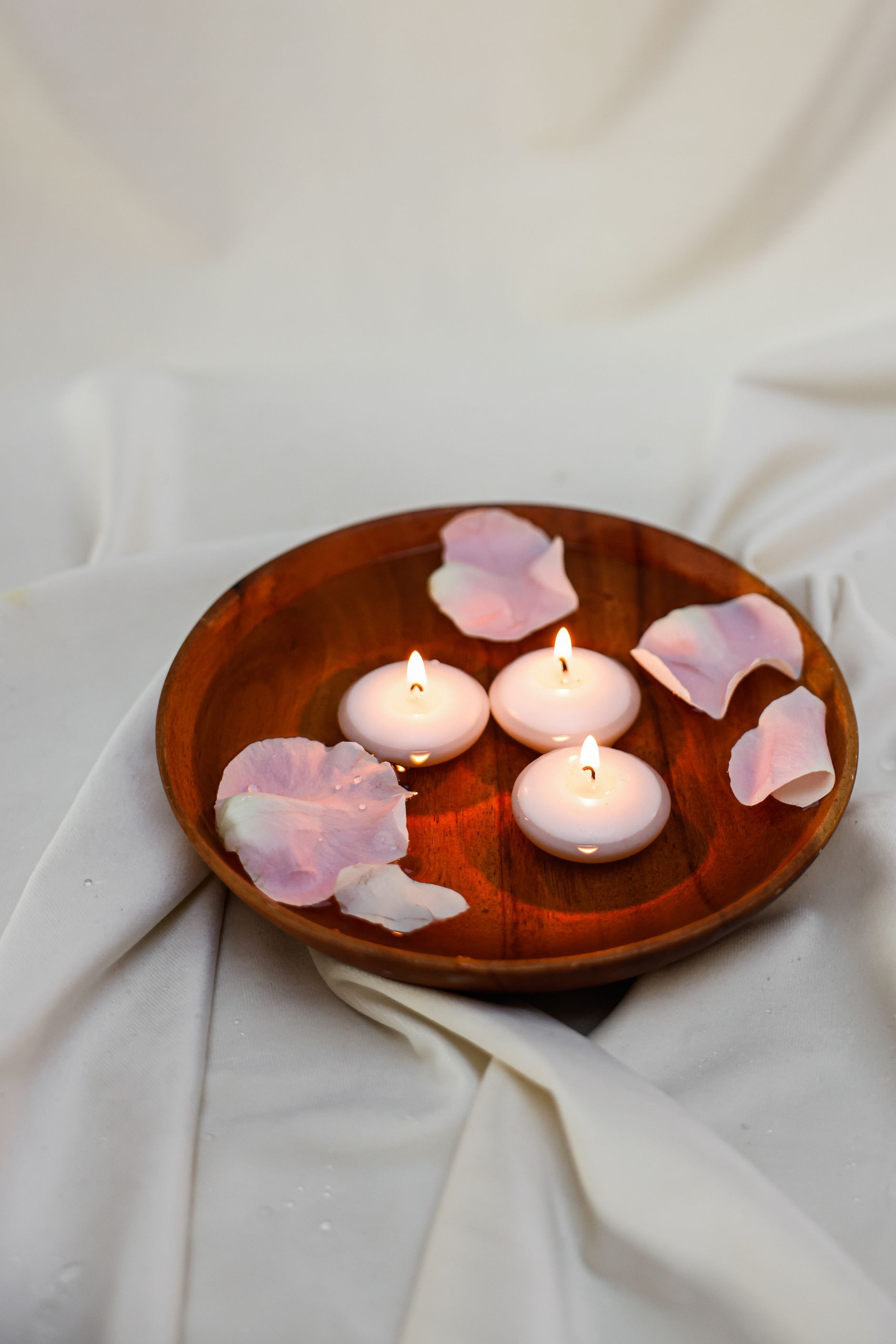 Floating candles in a wooden bowl