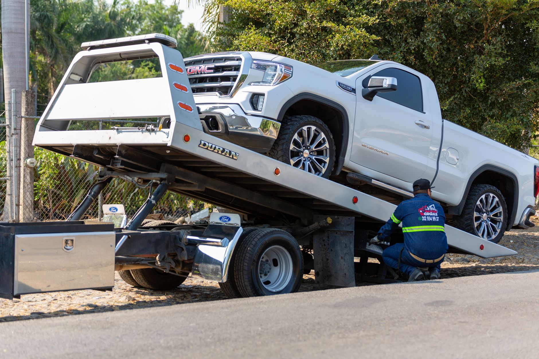 Tow operator loading a pickup onto a flatbed